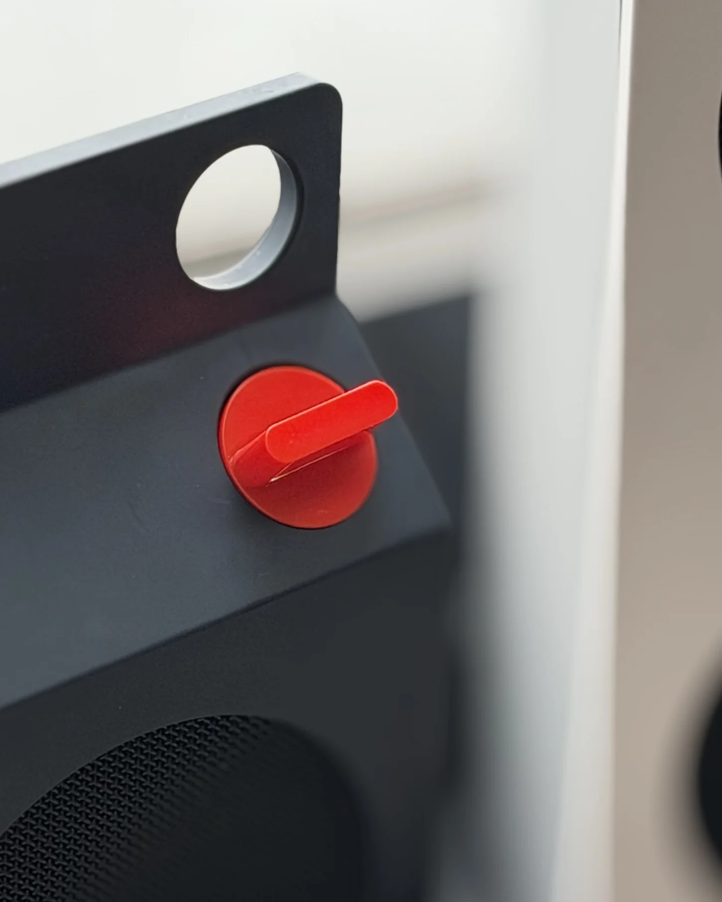 Close-up knob merah pada CMF Speaker S warna Dark Grey dengan lubang penyangkut