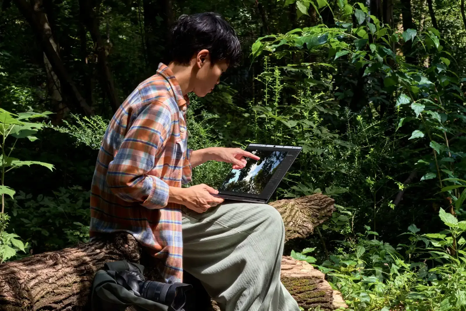 Gambar: Apple Pengguna guna MacBook Pro PROLED XDR di luar dalam cahaya terang di tengah hutan