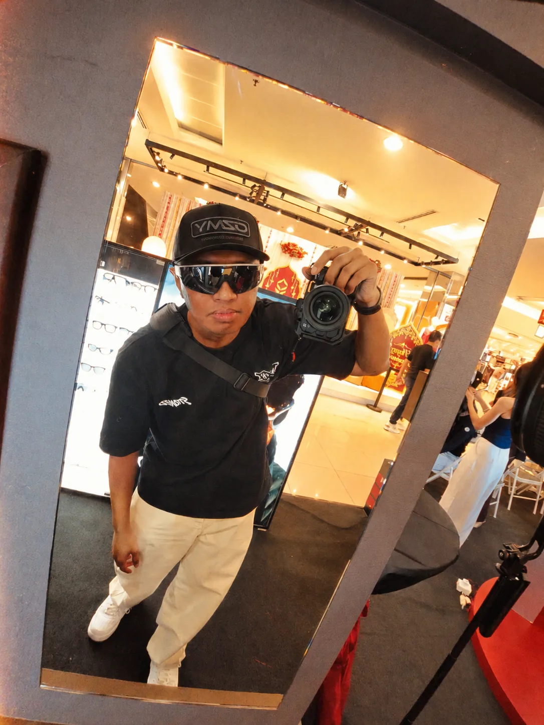 Mencuba Oakley Meta Vanguard kanta perak di depan cermin pop-up MOG 1 Utama sambil memegang kamera
