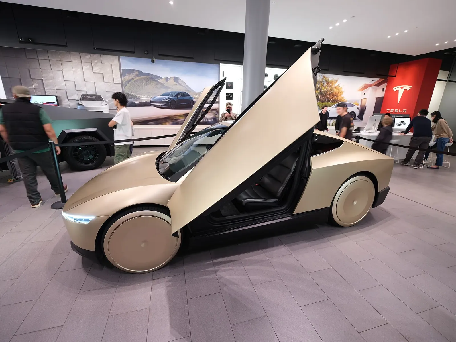 Gambar: Dllu / Wikimedia Commons (CC BY-SA 4.0) Tesla Cybercab dengan pintu butterfly terbuka dipamerkan di dalam showroom Tesla