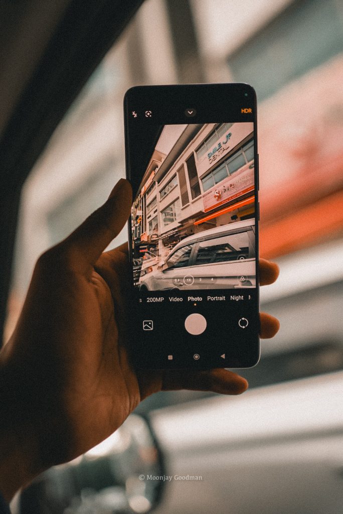Redmi Note 14 Pro+ camera app framing a row of shops and a parked car