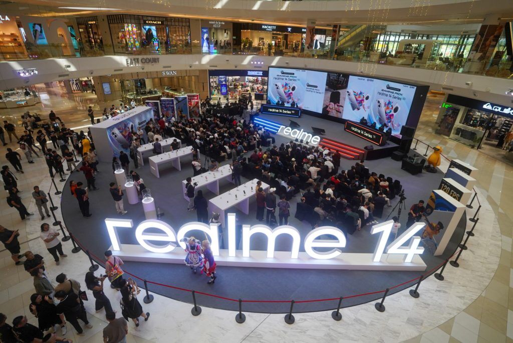 Giant glowing realme 14 sign in front of the packed launch stage
