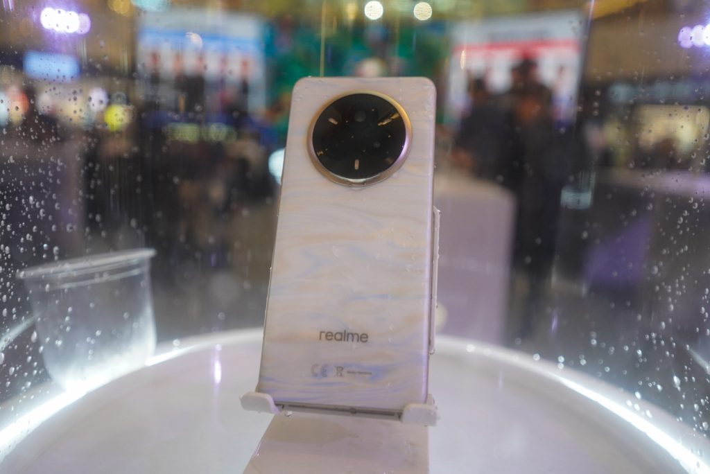 White Realme 14 Pro 5G in a water display showing its colour-changing back